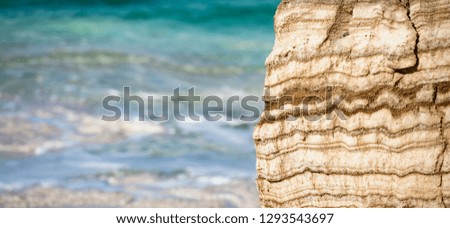 (selective focus) Close-up view of a limestone rock in the foreground and Dead Sea in the background, Israel.
