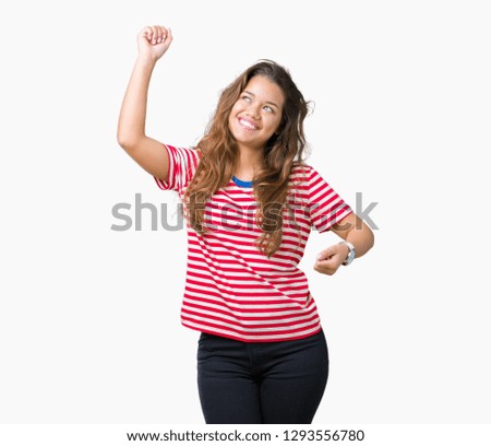 Young beautiful brunette woman wearing stripes t-shirt over isolated background Dancing happy and cheerful, smiling moving casual and confident listening to music