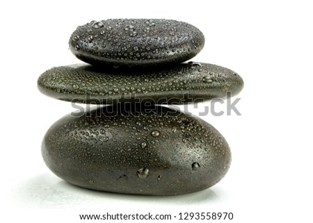 Balanced zen stones with drops of water on a white background
