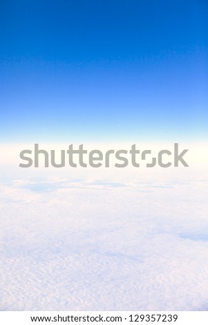 The bright blue sky with white clouds. Plane view from the window