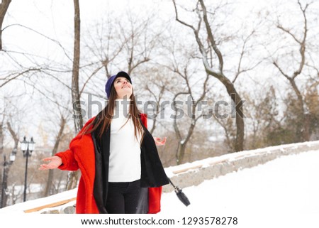 Picture of amazing beautiful young woman outdoors walking in snow winter park forest.