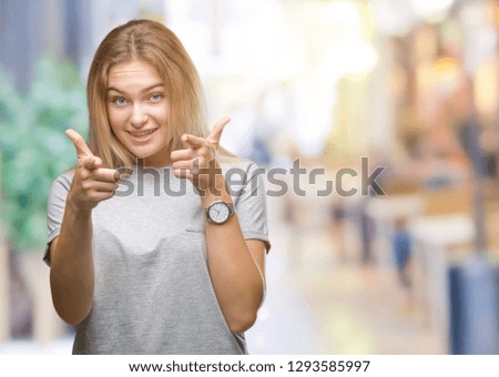 Young caucasian woman over isolated background pointing fingers to camera with happy and funny face. Good energy and vibes.