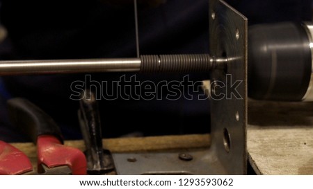 Worker makes a wire from a metal rod. Crafting at the workshop