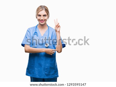 Young beautiful blonde doctor surgeon nurse woman over isolated background smiling with happy face winking at the camera doing victory sign. Number two.