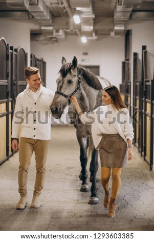 Couple in stable with horse