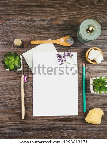 Natural nature friendly beauty products blogger concept. Various skin care treatment products on wooden table, white blank paper sheet with copy space in center, background, top view.