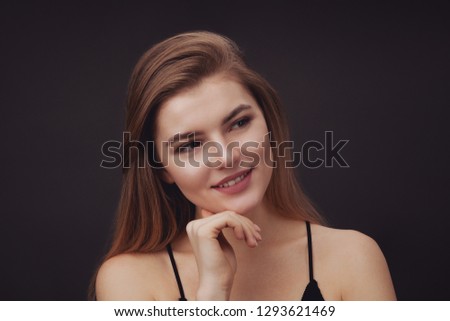 Young beautiful woman against dark background. Natural beauty