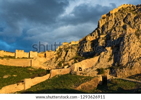 View of the archaeological site of Acrocorinth, the acropolis of ancient Corinth in Peloponnese, Greece at sunset Royalty-Free Stock Photo #1293626911