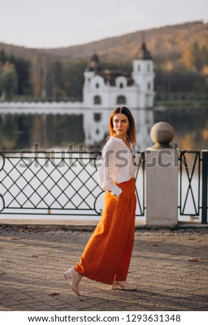 Woman by the castle and lake posing