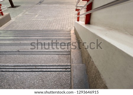 Upper floor view of cement stairs with hand railing stainless look toward to down floor and cement pavement with copy space