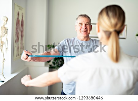 A Modern rehabilitation physiotherapy worker with senior client Royalty-Free Stock Photo #1293680446