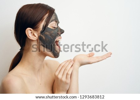 happy woman in a cosmetic mask of clay on her arm free place