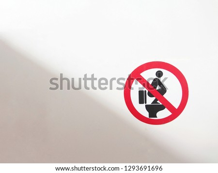 Sticker warning; Don't step on the toilet seat, on the toilet wall