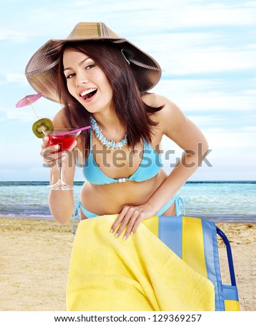 Girl in bikini drink juice on beach. Outdoor.