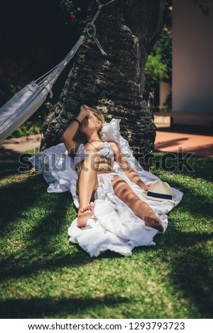 Young slim women relaxing sunbathing tanning in the garden on the grass.