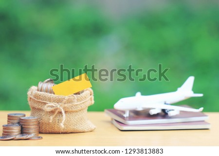 Stack of coins money in the bag and airplane on passport with natural green background, Saving planning for Travel budget of holiday concept