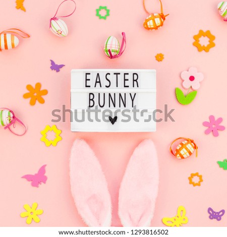 Creative Top view flat lay holiday composition Easter bunny text on lightbox pink paper background copy space Template Easter day seasonal pattern