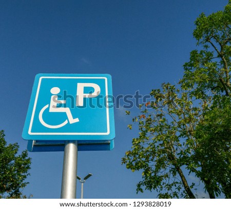 symbols for wheelchair parking sign on backdrop sky