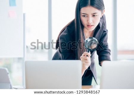 Business women searching through computer data looking for malware, virus, or other embedded data.