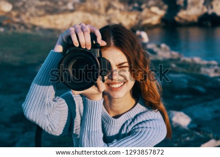 A cheerful woman photographer takes pictures of nature