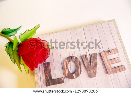 Valentine's Day concept. Romantic still life, Red rose and wooden board with text LOVE isolated white background. Top view with copy space.