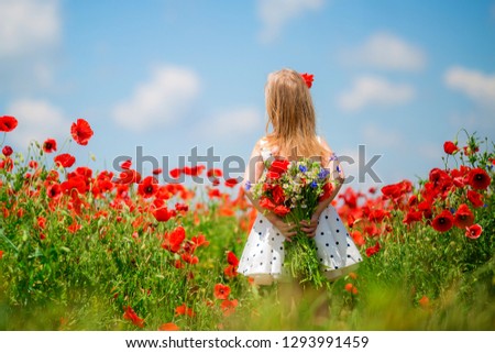 baby girl stands back and looks at the field of flowers. baby girl stands with her back.one child stands with his back