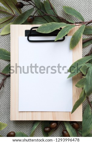 Styled stock photograph with some hand drawn arrangements. blank space for wording. Botanical setting. Wooden clipboard placed on simple chevron fabric. Marble background. Crafting table setting. 