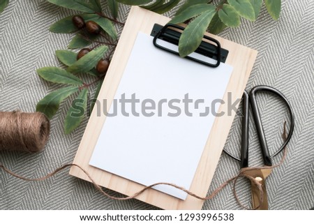 Styled stock photograph with some hand drawn arrangements. blank space for wording. Botanical setting. Wooden clipboard placed on simple chevron fabric. Marble background. Crafting table setting. 