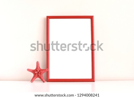Empty red frame mock up and star fish on white table.