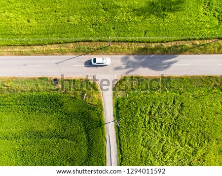 aerial view of t-junction with a car in countryside