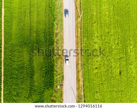 aerial view of straight road in countryside with car.