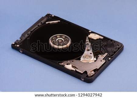 Opened disassembled hard drive from the computer laptop, hdd with mirror effect. on blue background