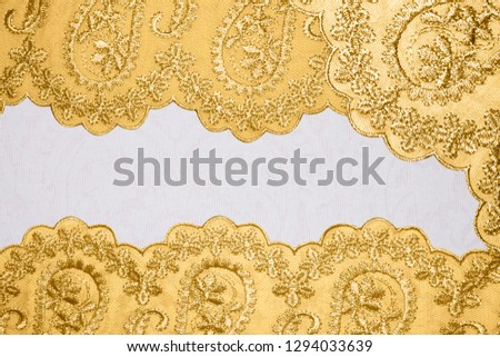 Gold lace on white fabric.Background with gold patterns.
