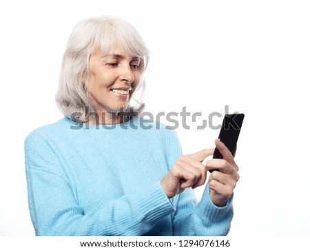 Lifestyle, tehnology  and people concept: senior woman with smartphone texting isolated on white background