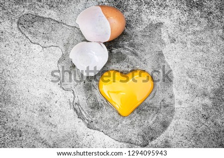 Heart Shape Egg Yolk with eggshells on the ground. Concept Valentines Day