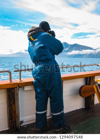 Photographer on a eco-friendly whale watching ship in Husavik, on the north coast of Iceland