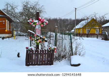 Cross on crossroad in village of Belarus in winter day. Old wooden cross.