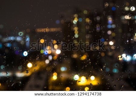 Raindrops on the window, against the backdrop of the night city. Background, screen saver, wallpaper.