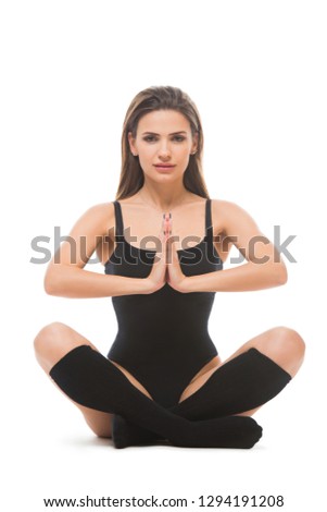 Slim woman doing yoga asana isolated on white background. Young Female wearing sport clothes in lotus pose.