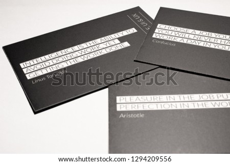 Black business cards on white background. Code, web design, UI & UX. White letters, with quote on back