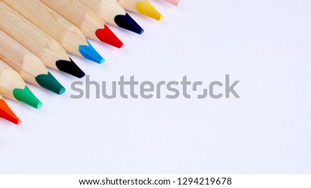 Colored pencils on a white background close up in macro photography. Art set of pencils with free space.