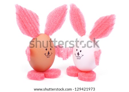two Easter bunny with pink ears holding hands made of white and brown eggs isolated on white background. humorous postcard
