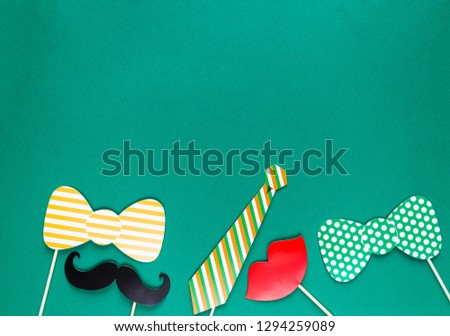 Creative st Patricks Day green background. Flat lay composition of Irish holiday celebration with photo booth decor: glasses, bow tie, moustache. With Copy space, greeting card, top view