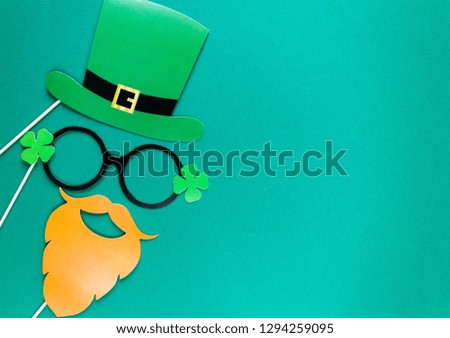 Creative st Patricks Day green background. Flat lay composition of Irish holiday celebration with photo booth decor: glasses, bow tie, moustache. With Copy space, greeting card, top view