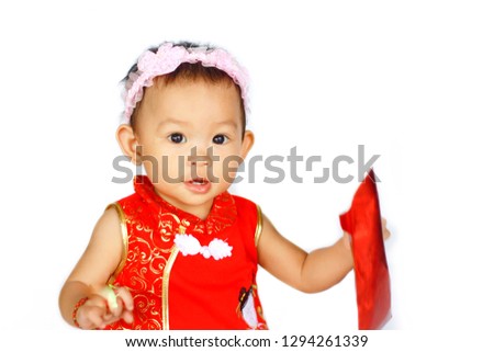 Soft focus, Chinese New Year festival concept, a Chinese 's baby girl in the red clothes. She holding a pocket money gift in her hand. On white background. 
