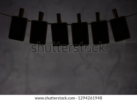 wooden signs hang on clothespins. dark background.
