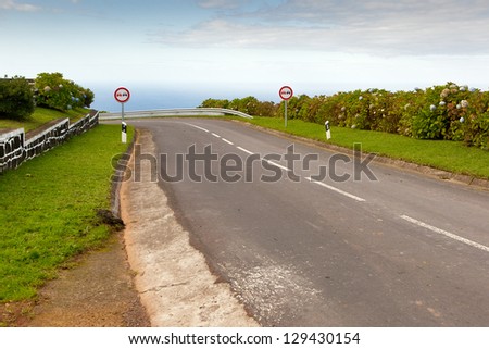 Empty road to the ocean with two signs, San Miguel, Azores, Portugal