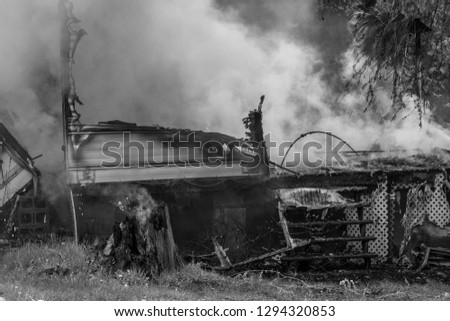 Monochrome picture featuring camper burning to the ground