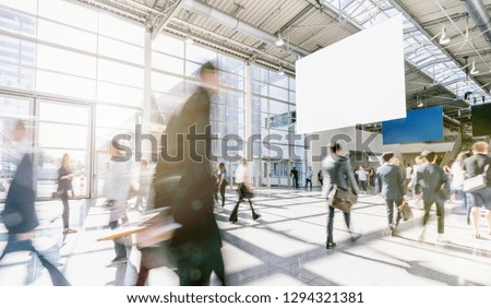 blurred business people at a trade fair, with copy space banner