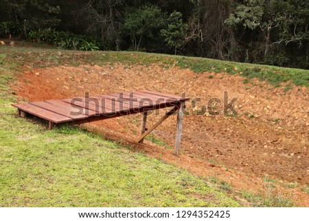 Drought concept image consisting of a dry dam and a wooden jetty. 